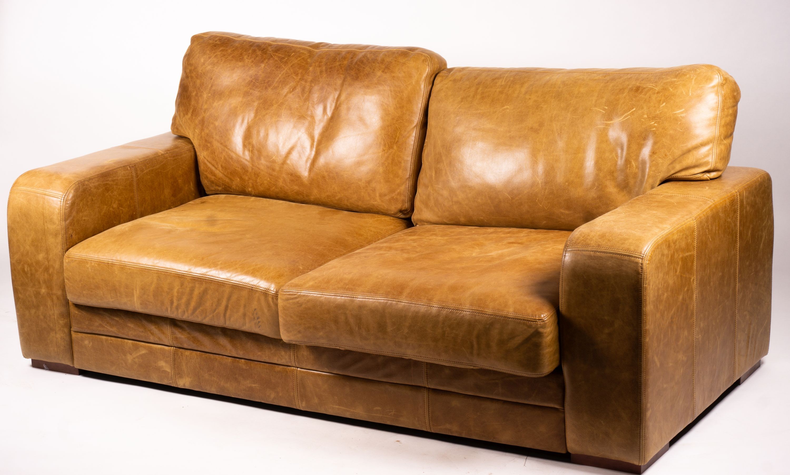 A pair of contemporary tan leather settees, length 200cm, depth 100cm, height 94cm